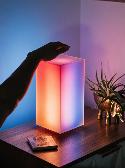 Lumen smart LED lamp glowing softly on a bedside table
